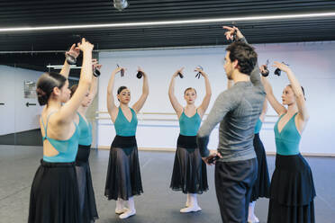 Lehrer, der Schülern beim Üben des Flamenco-Tanzes im Studio hilft - MRRF02742