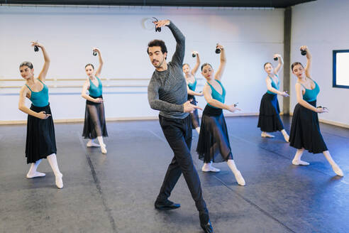 Instructor dancing with flamenco dancers in studio - MRRF02744