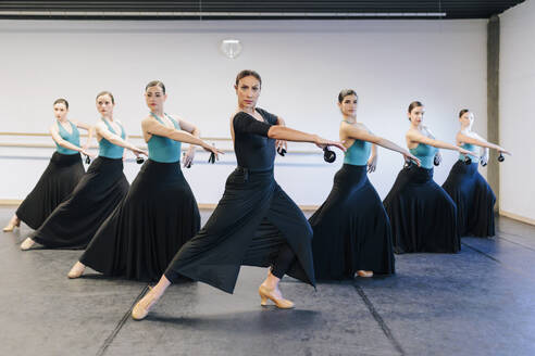 Selbstbewusste Lehrerin unterrichtet Flamenco-Tanzschüler im Studio - MRRF02747
