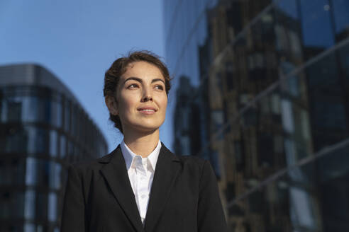 Contemplative businesswoman near buildings - VPIF09204