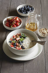 Studioaufnahme einer Schüssel Porridge mit Blaubeeren und Erdbeeren - EVGF04454
