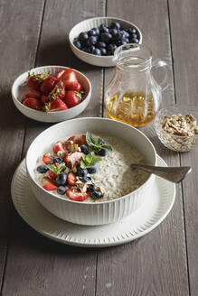 Studio shot of bowl of porridge with blueberries and strawberries - EVGF04454
