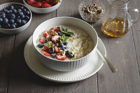 Studioaufnahme einer Schüssel Porridge mit Blaubeeren und Erdbeeren - EVGF04455