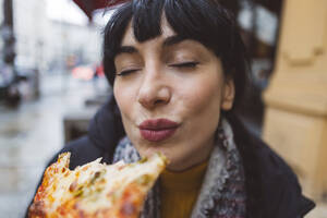 Frau genießt Pizza mit geschlossenen Augen - JCCMF11086