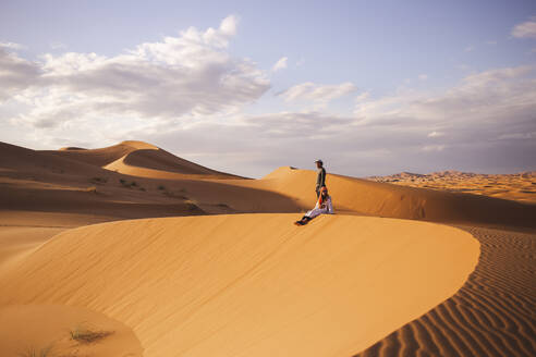 Mann und Frau auf einer Sanddüne in der Wüste Sahara in Marokko, Afrika - PCLF00913