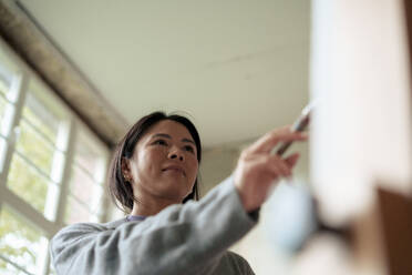 Confident painter painting on canvas in workshop - JOSEF22761