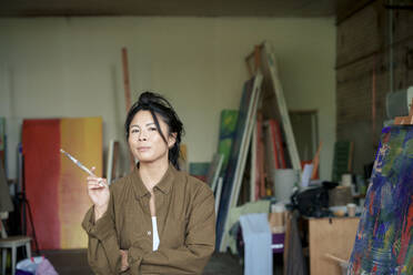 Selbstbewusster Maler mit Pinsel beim Malen in der Werkstatt - JOSEF22844