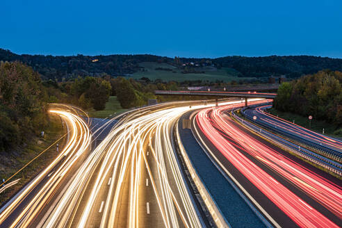 Germany, Baden-Wurttemberg, Leonberg, Vehicle light trails stretching along Bundesautobahn 8 at dusk - WDF07501