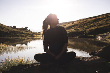 Woman sitting on rock in front of Abudelauri lake at sunrise - PCLF00947