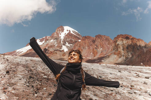 Carefree woman in front of mount Kazbek on sunny day - PCLF00952