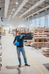 Architekt mit Schutzhelm macht Selfie mit Smartphone in der Werkstatt - JOSEF22921