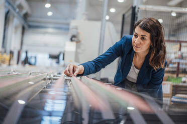 Geschäftsfrau beim Analysieren von Maschinen in einer Werkstatt - JOSEF22959