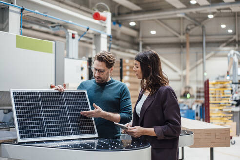 Geschäftsmann diskutiert mit Kollege über Solarpanel in der Industrie - JOSEF23000