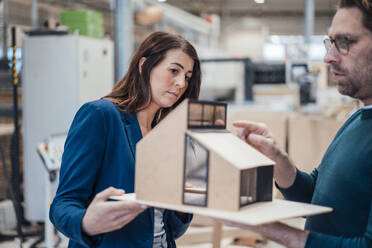 Architects examining model house standing in workshop - JOSEF23010