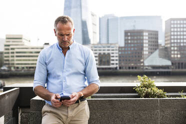 Businessman using smart phone in London, UK - WPEF08015