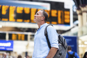 Mature businessman with backpack at railroad station - WPEF08059