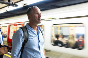 Älterer Geschäftsmann wartet auf dem Bahnsteig auf einen Zug - WPEF08069