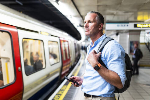 Businessman in blue shirt waiting for train on platform - WPEF08075