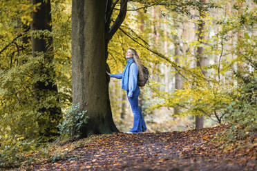 Lächelnde Frau in der Nähe eines Baumes im Cannock Chase Forest - WPEF08076