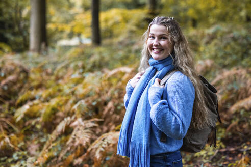 Lächelnde schöne Frau mit Rucksack im Wald von Cannock Chase - WPEF08078