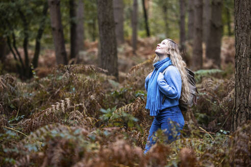 Lächelnde junge Frau mit Rucksack im Cannock Chase Forest - WPEF08084