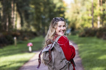 Happy woman with backpack in Cannock chase forest - WPEF08116