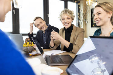 Smiling colleagues discussing business strategy in meeting at office - PESF04216