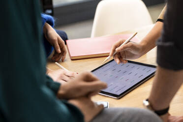 Kollegen bei der Arbeit im Büro mit einem Tablet-PC auf dem Schreibtisch - PESF04222