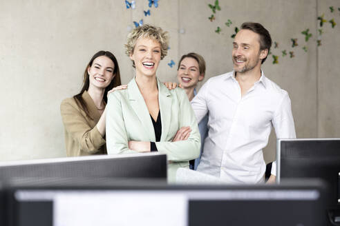 Cheerful business colleagues standing in office - PESF04238