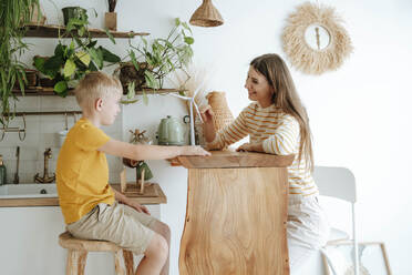 Mother and son at home with wind turbine model - WESTF25301
