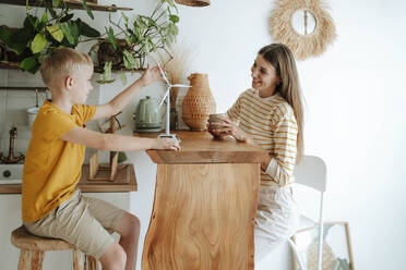 Mother and son at home with wind turbine model - WESTF25302