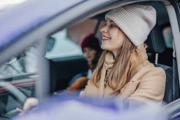 Lächelnde Frau beim Autofahren im Winter - VSNF01542