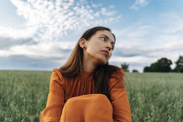 Thoughtful woman sitting in corn field - TOF00178