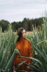 Thoughtful woman standing amidst corn crops in field - TOF00189