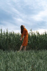 Woman with head back in corn field at sunset - TOF00201