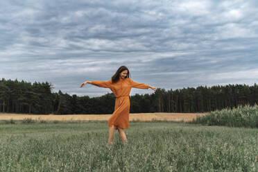 Carefree woman dancing amidst crops in field - TOF00209