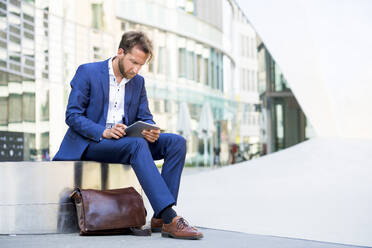 Businessman working on tablet PC in the city - PUF02019