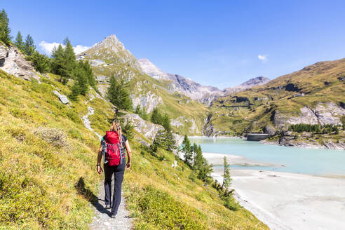 Frau beim Wandern in der Nähe des Margaritzestausees unter freiem Himmel im Nationalpark Hohe Tauern, Salzburg, Österreich - FOF13734