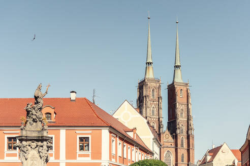 Poland, Lower Silesian Voivodeship, Wroclaw, Statue of John of Nepomuk with Cathedral of St. John Baptist in background - TAMF04104