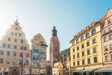 Poland, Lower Silesian Voivodeship, Wroclaw, Historic houses surrounding market square with tower of St Elizabeths Church in background - TAMF04111