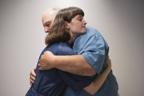 Side view of father hugging daughter - AMWF01970