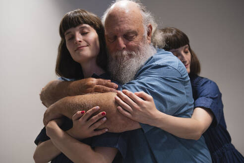 Father and two daughters hugging - AMWF01973