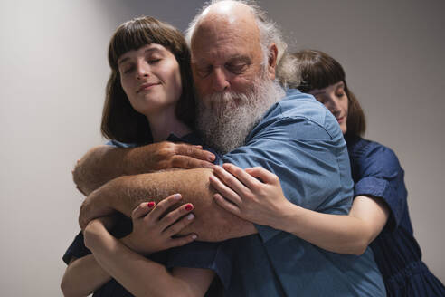 Vater und zwei Töchter, die sich umarmen - AMWF01973