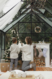 Mutter und Sohn schmücken den Weihnachtsbaum zu Hause - EHAF00160