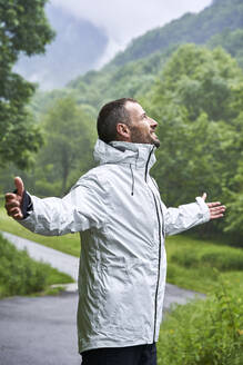 Glücklicher Mann mit weißer Jacke vor dem Berg der Pyrenäen - VEGF06232