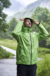 Lächelnder Mann mit grüner Jacke vor einem Berg der Pyrenäen - VEGF06237