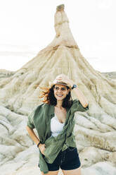 Happy tourist wearing hat standing near Castildetierra - DAMF01236