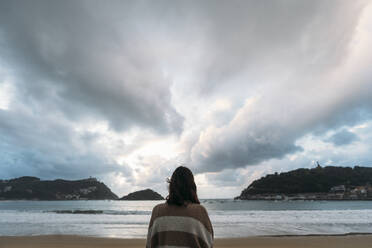 Junge Frau am Playa de la Concha bei bewölktem Himmel - DAMF01249