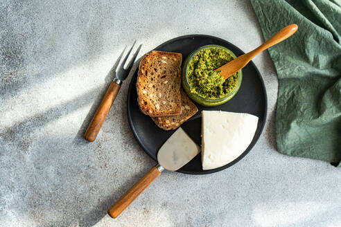 Draufsicht auf einen Teller mit köstlicher hausgemachter Brot-Käse-Sauce, serviert auf einem grauen Tisch mit Besteck und Serviette - ADSF51807