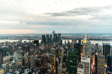 Drone view of standing close high buildings with glass windows in Manhattan in downtown of New York city against cloudy sky - ADSF52029